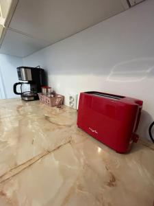 a red toaster sitting on a counter in a room at SJ Apartment in Tulcea