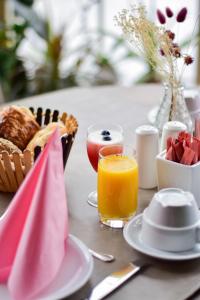 B&B Fruithof Tack في Sint-Gillis-Waas: طاولة مع سلة من الخبز وكوب من عصير البرتقال