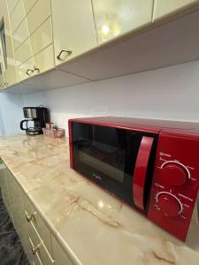 a red microwave sitting on top of a kitchen counter at SJ Apartment in Tulcea