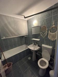 a bathroom with a toilet and a sink and a tub at SJ Apartment in Tulcea