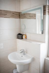 a white bathroom with a sink and a mirror at Havelstern Ketzin, Ferienhaus Hecht in Ketzin