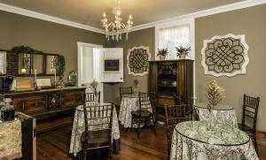 a living room with chairs and tables and a chandelier at Carriage Way Inn Bed & Breakfast Adults Only - 21 years old and up in St. Augustine