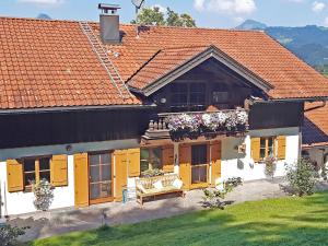 een huis met gele deuren en een bank ervoor bij Ferienwohnung im Brechstubenweg in Kiefersfelden