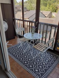 a balcony with a table and chairs on a balcony at Entre terre et mer in Oloron-Sainte-Marie