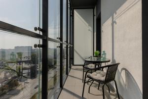a balcony with a table and chairs on a building at Pet-Friendly Apartment Prymasa Tysiąclecia by Renters in Warsaw