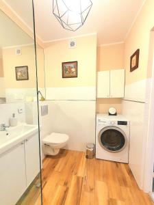 a bathroom with a washing machine and a toilet at Apartament Trzy Sypialnie Stare Miasto in Elblag