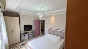 een kleine kamer met een bed en een televisie bij Cleopatra plajına 50mt deniz gören ferah 2+1 daire in Alanya