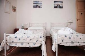 2 camas en una habitación con paredes blancas en Casa elegante in mezzo al verde, en La Spezia