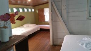 a room with two beds and a staircase in it at Posada Ecoturística El Valle in El Valle