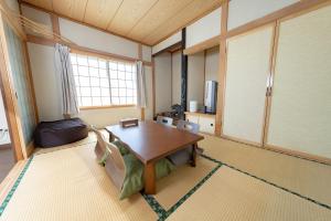 a living room with a wooden table and a couch at Furano Retreat in Furano