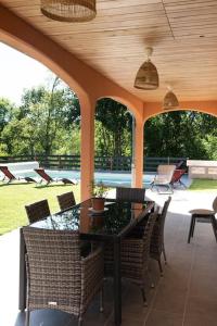 un patio con mesa y sillas en Villa neuve avec piscine 6 personnes en limousin en Ladignac-le-Long