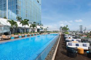 a large swimming pool with lounge chairs and a building at Courtyard by Marriott Colombo in Colombo