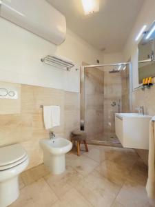 a bathroom with a toilet and a sink and a shower at Suite con giardino in La Maddalena