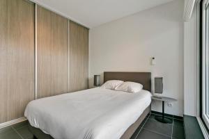 a bedroom with a large white bed and a table at Apartment in Heart of Brussel City with Balcony View in Brussels