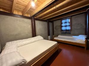two beds in a room with a window at SaPa Hmong Streamside Homestay in Sa Pa