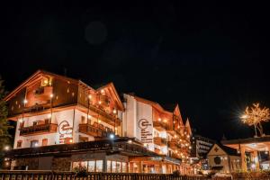 un grand bâtiment avec des lumières allumées la nuit dans l'établissement Hotel Cima Rosetta - BW Signature Collection, à San Martino di Castrozza