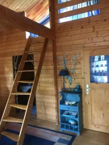 a loft bed in a log cabin with a ladder at Ferienhaus Nele - a90930 in Kühlungsborn