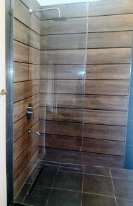 uma casa de banho com um chuveiro e uma parede de madeira em CASA ARISTIDES em Mendoza