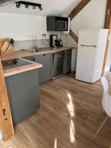 阿澤勒里多的住宿－Gîte au 1er étage avec jardin，厨房铺有木地板,配有白色冰箱。