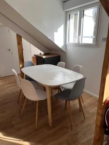 una mesa blanca y sillas en una habitación en Gîte au 1er étage avec jardin, en Azay-le-Rideau