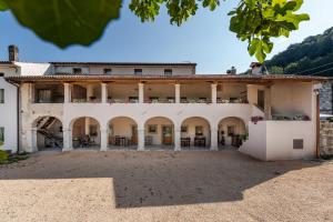 an external view of a large white building with columns at Agriturismo Il Bosco Camere in Vittorio Veneto