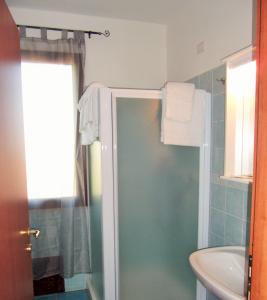een badkamer met een douche en een wastafel bij Hotel Bellavista S'Archittu in S'archittu Cuglieri
