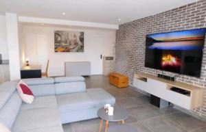 a living room with a couch and a flat screen tv at Stunning T4 Musardière in Antibes