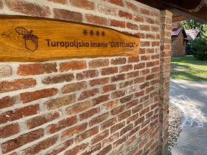 Gustelnica的住宿－Turopoljsko imanje GUSTELNICA，砖墙边的标志