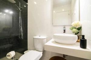 uma casa de banho com um WC branco e um lavatório. em RECANTO DO AÇOR Holiday Accommodation em Ponta Delgada