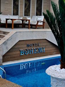 Hotel Bohemi في هاسكوفو: لافته تقول فندق بوهيمي بجانب مسبح