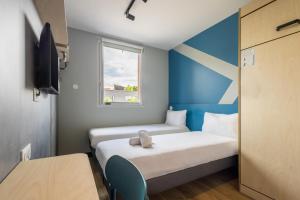 Postel nebo postele na pokoji v ubytování ibis budget Nanterre la Defense