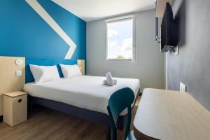 Postel nebo postele na pokoji v ubytování ibis budget Nanterre la Defense