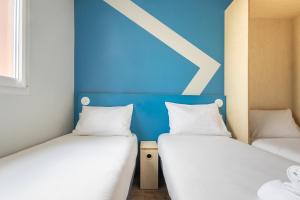 Postel nebo postele na pokoji v ubytování ibis budget Nanterre la Defense