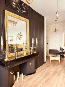 ein Bad mit einem Spiegel und einem Klavier in einem Zimmer in der Unterkunft Love room « L'étreinte dorée » in Illiers
