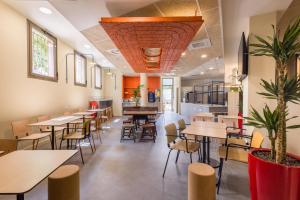 a restaurant with tables and chairs and a cafeteria at ibis budget Nanterre la Defense in Nanterre