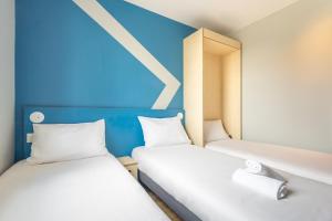 Postel nebo postele na pokoji v ubytování ibis budget Nanterre la Defense