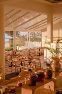 een restaurant met houten tafels en stoelen en een patio bij Hotel Riomar, Ibiza, a Tribute Portfolio Hotel in Santa Eularia des Riu