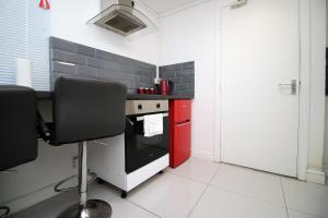 a kitchen with a stove and a red refrigerator at Lovely Studio Flat, Free Parking-Near City Centre in Swansea