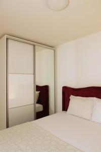 a bedroom with a white bed and a mirror at Skywalk House in Mostar