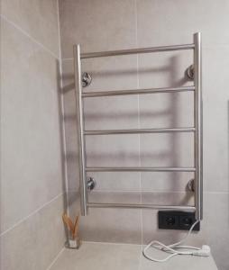 a shower with metal towel racks in a bathroom at Bridge Apartments Klaipeda in Klaipėda