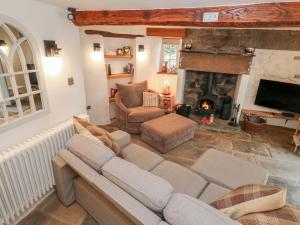 a living room with a couch and a fireplace at Lydgate Cottage in Eyam