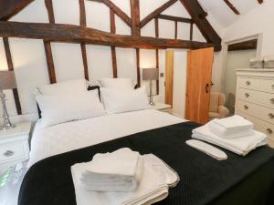 Schlafzimmer mit einem Bett mit weißer Bettwäsche und weißen Handtüchern in der Unterkunft Lydgate Cottage in Eyam