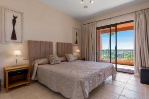 1 dormitorio con cama y ventana grande en Los Flamingos Luxurious-Royal Flamingos, en Estepona