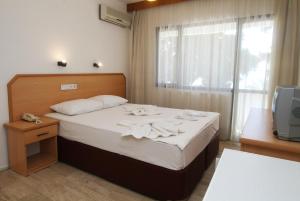 a hotel room with a bed with towels on it at Goren Hotel in Çeşme