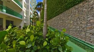 un edificio con un montón de plantas al lado de una pared en Residencial Paradisus, en San José