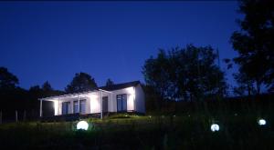 a small house lit up at night with lights at Osada Solasu in Złoty Stok