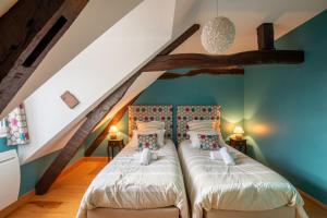 2 camas en un dormitorio ático con paredes azules en Gite des Gargouilles, en Saint-Valery-sur-Somme