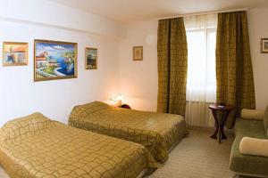 a hotel room with two beds and a window at Family Art Hotel Gallery in Pleven