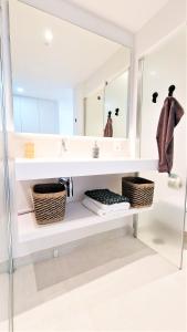 bagno con ripiani bianchi e specchio di AA Guest - Luxury Paradise Eco Apartment Higueron a Fuengirola