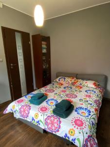 a bedroom with a bed with a floral bedspread at DOM NA KASZUBACH, SAUNA i BALIA in Nowe Czaple